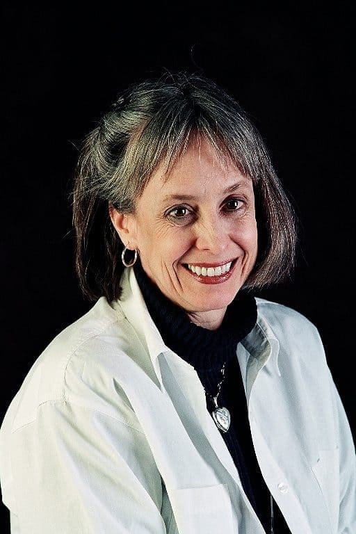 Smiling woman in white lab coat.