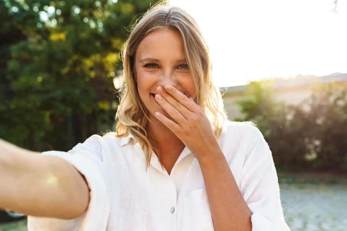 Test Homepage New 1 Smiling woman taking a selfie outdoors.